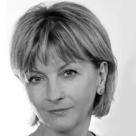 A black and white photo of a woman with short, light hair and bangs, looking into the lens with a neutral expression.